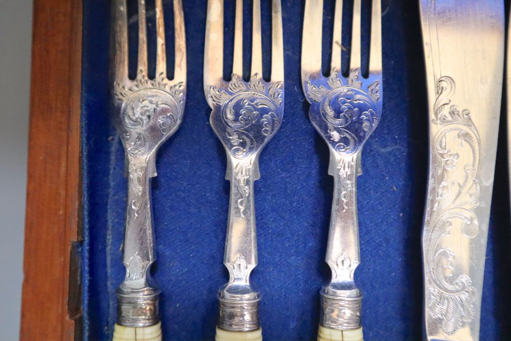 A Victorian set of twelve plated and engraved fish knives and forks, with carved ivory handles, mahogany cased